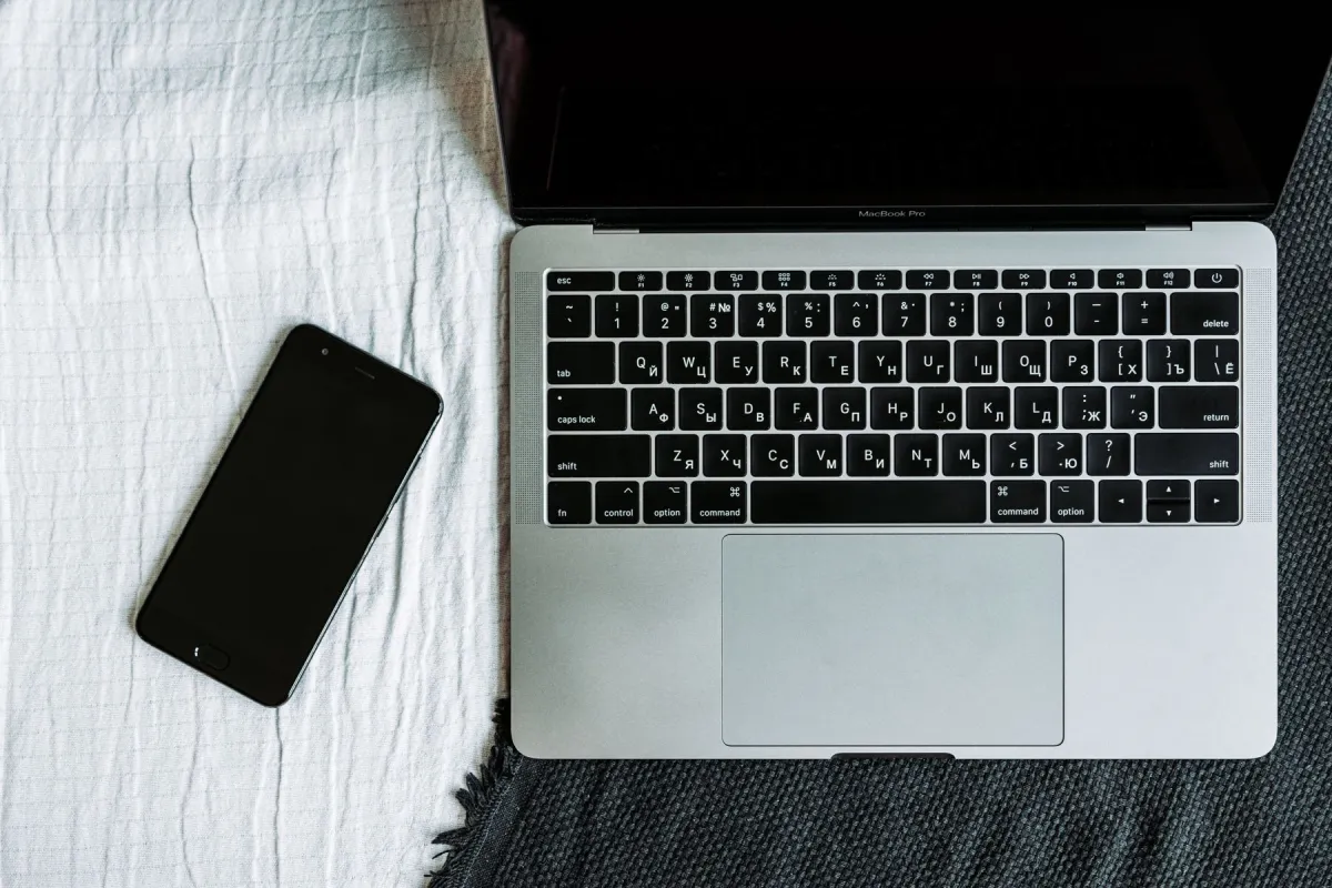 Laptop and smartphone arranged together on a textured surface