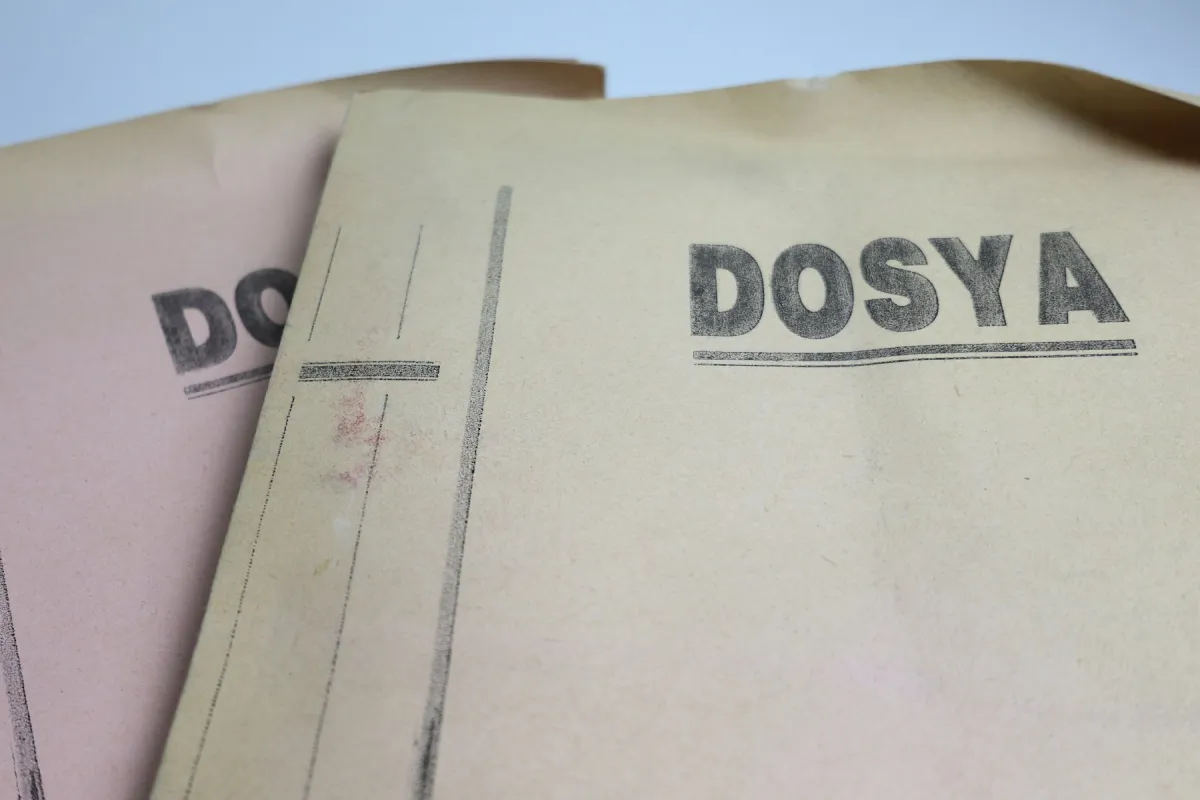 Two overlapping worn paper folders, the front one labelled DOSYA in large black letters.