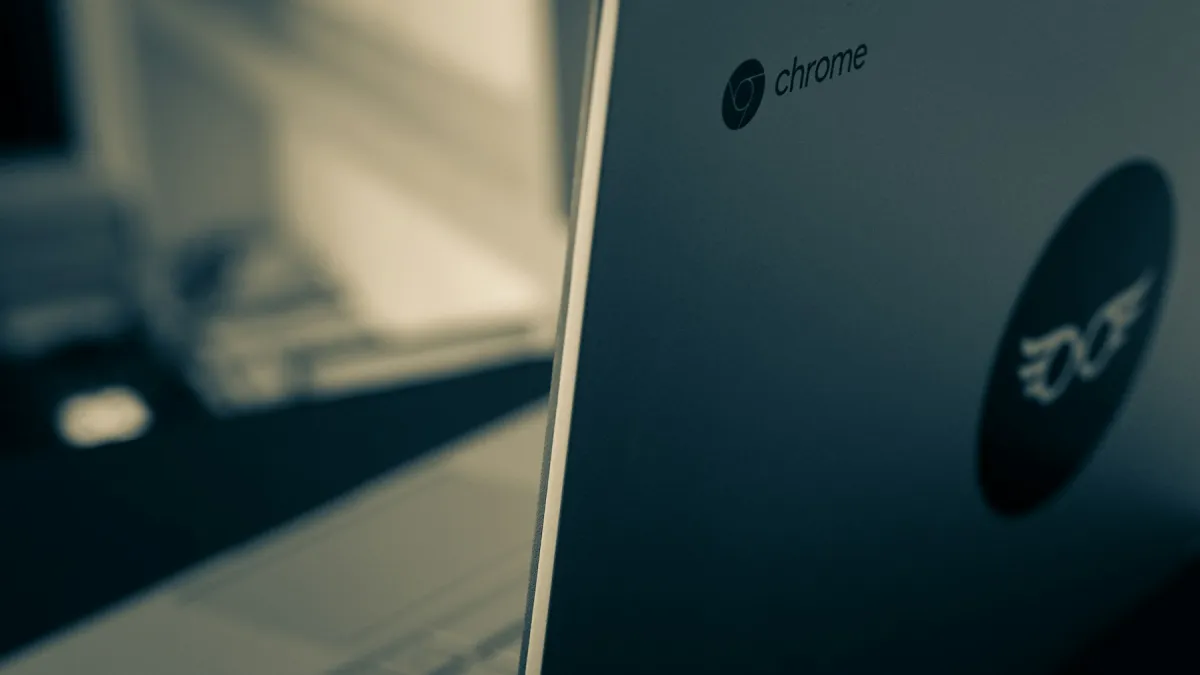 Close view of an Acer Chromebook lid with Chrome and Acer logos beside a softly lit window.