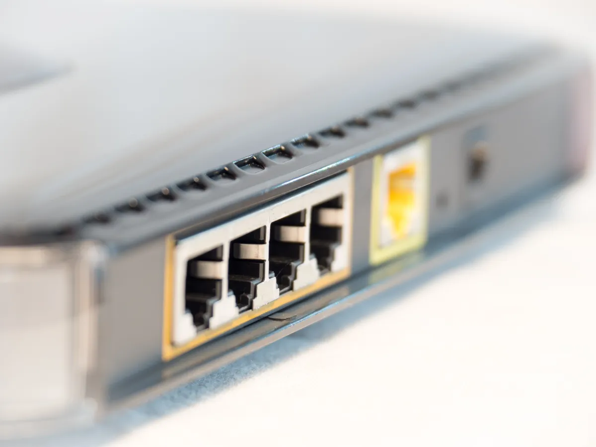 Shallow-focus close-up of four Ethernet sockets and an adjacent yellow socket on network equipment.