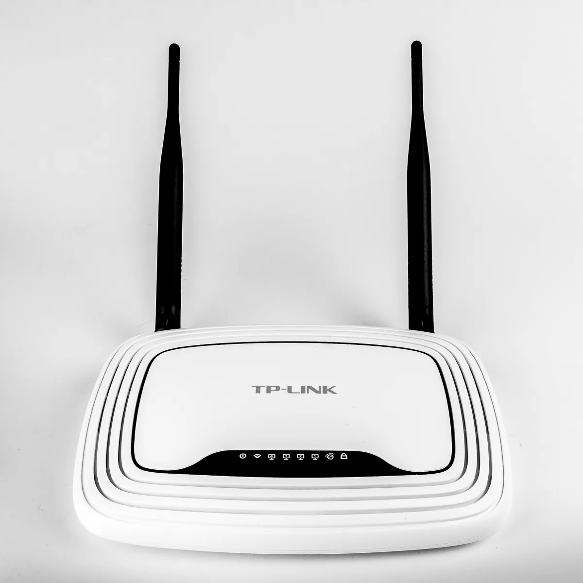 White TP-Link TL-WR841N router with two black antennas, photographed from above on a pale background.