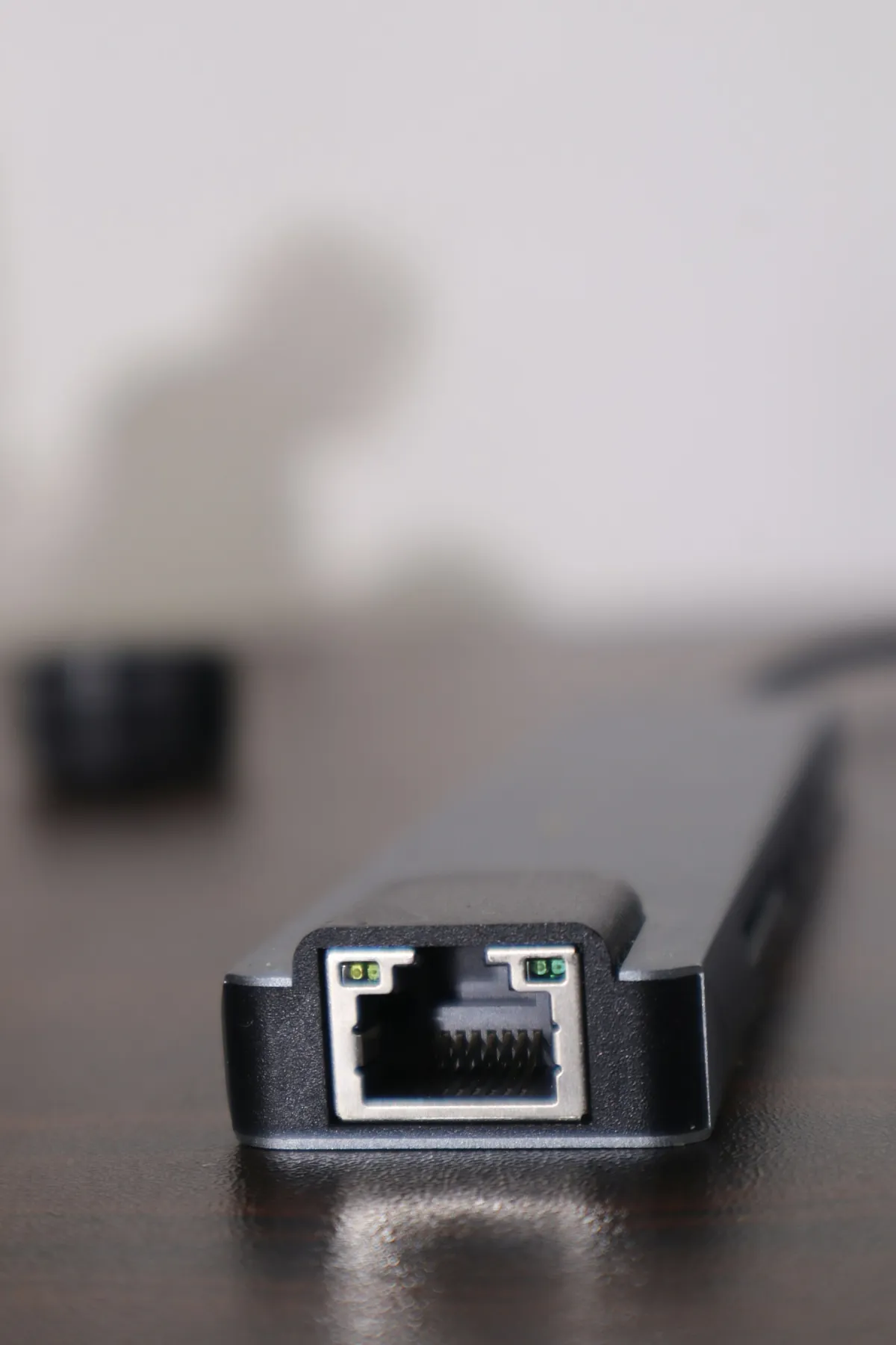 Close-up of an empty Ethernet socket on a black adapter resting on a table.